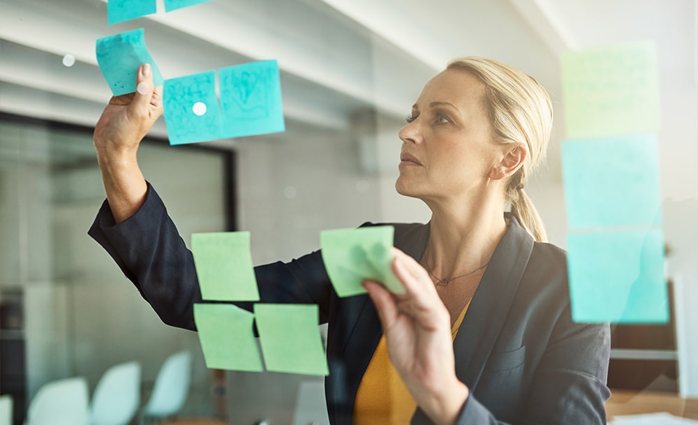 woman ceo putting sticky notes for delegating tasks