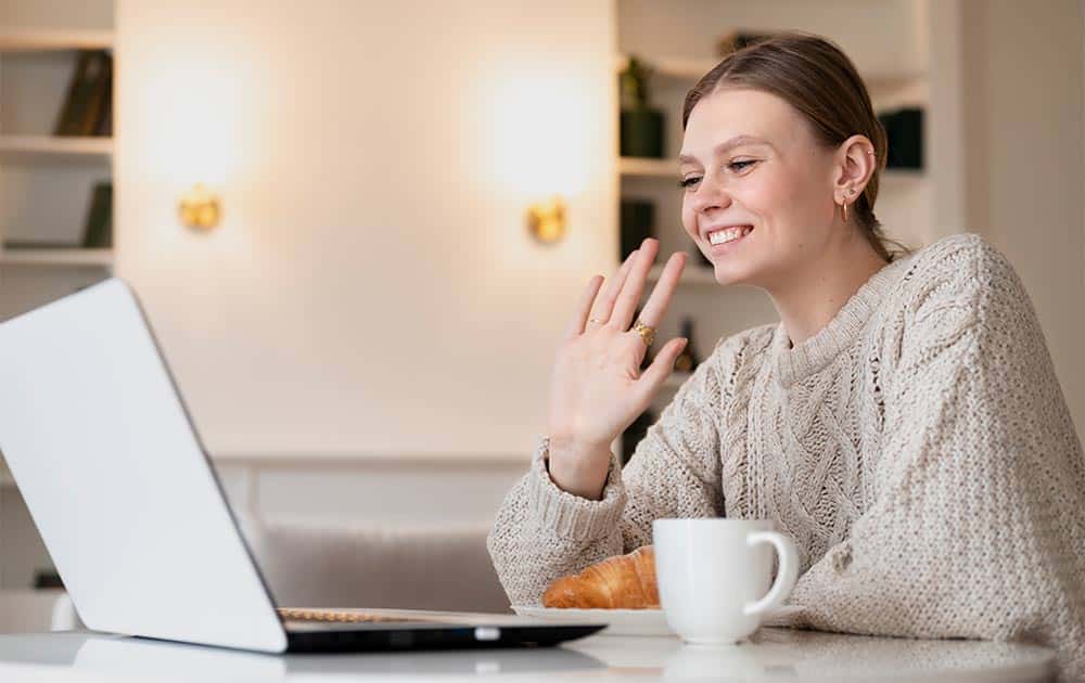 professional women smiling and collaborating during a supportive team meeting on a video call.