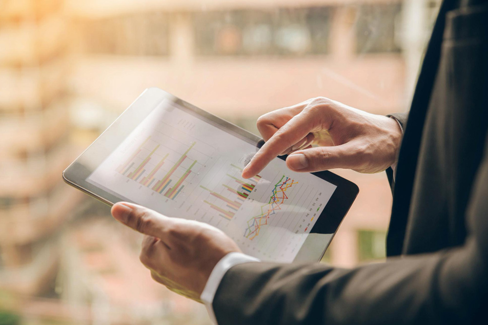 A business executive analyzing a digital chart that illustrates the various factors influencing the cost of hiring an executive assistant, such as experience level and location.